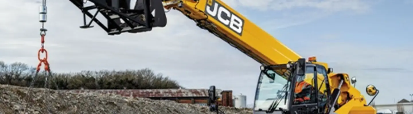 Worker operating machinery at a construction site during safety barrier installation to improve roadside protection.