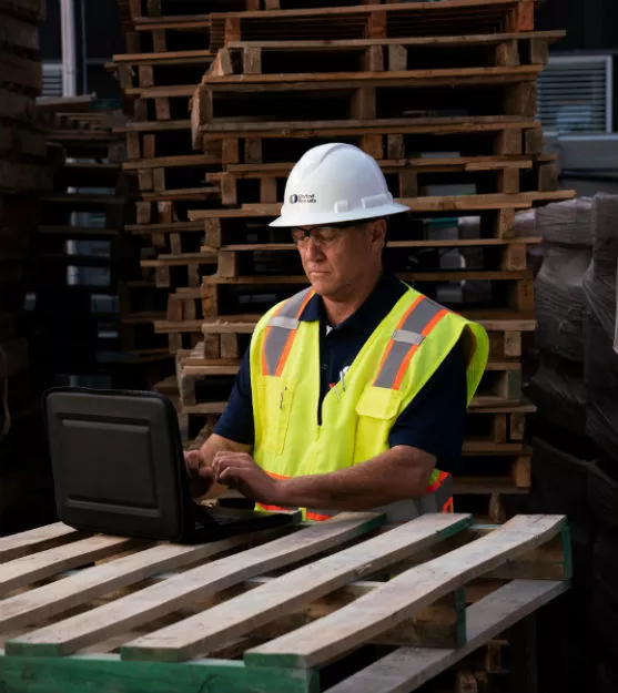 man in hardhat on computer