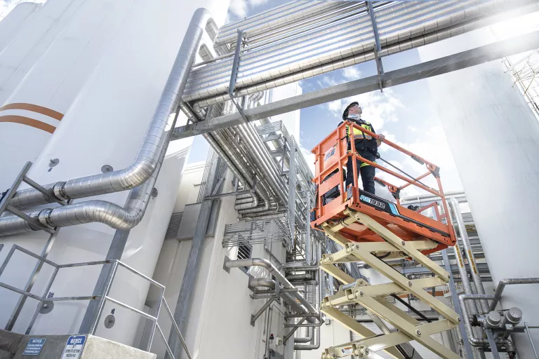 Worker on a scissor lift wearing PPE