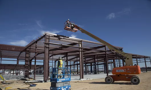 Workers using lifts at a job site