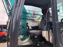 Competent operator skillfully controlling an excavator at a construction site focused on installing safety barriers.