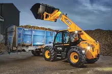 Standby compaction roller parked near construction barriers, ready for ground stabilization work on the site.