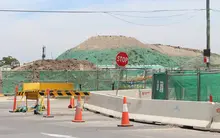 Different types of safety barriers placed along a road construction zone to manage traffic and protect workers.