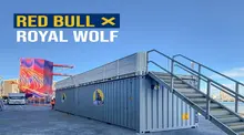 Two shipping containers converted into viewing platforms overlooking a cliff diving event, with safety barriers in place.