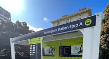  Temporary bus shelter constructed from repurposed container hoardings, providing shelter and seating for waiting passengers.